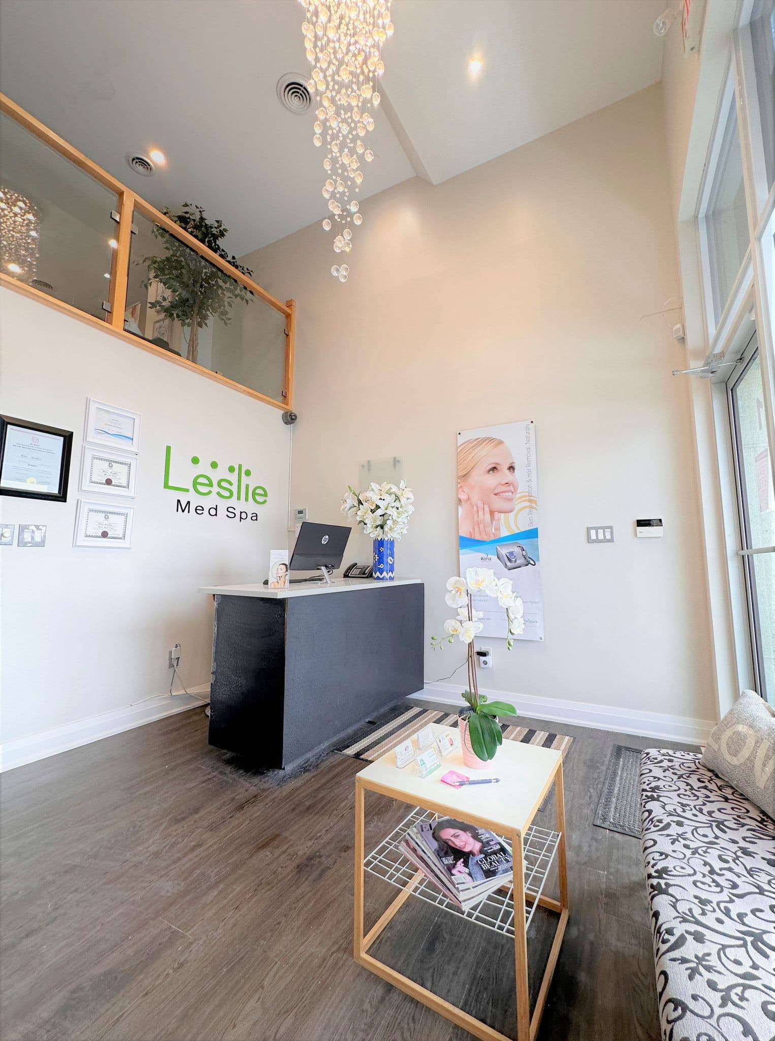 Reception area at Leslie Med Spa Newmarket — Leslie Med Spa logo on the wall, crystal chandelier, and welcoming front desk